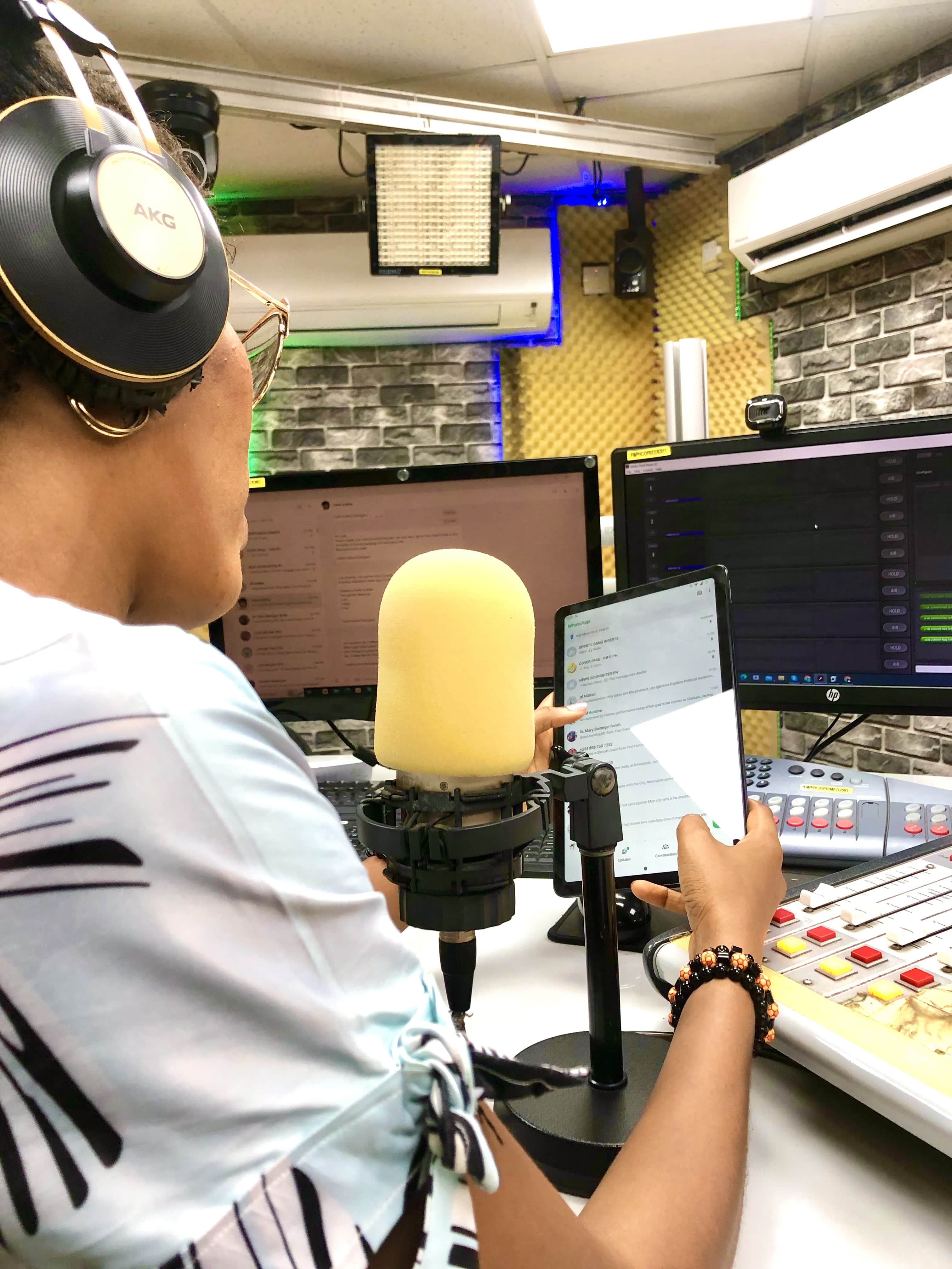 Dorcas Koki preparing notes on-air with headphones